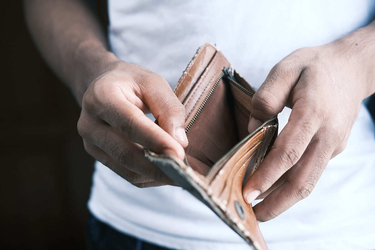 man looking inside an empty wallet