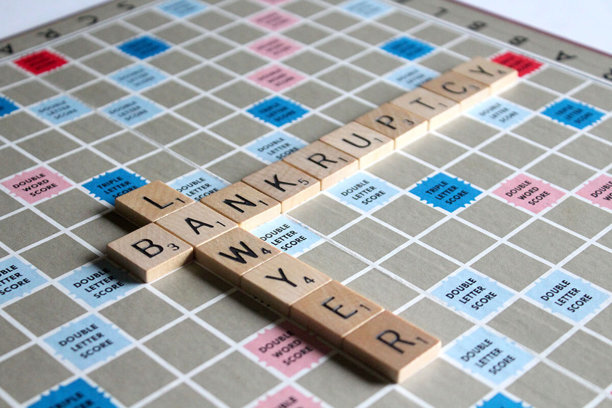 Scrabble board with the words 'bankruptcy' and 'lawyer' spelled out